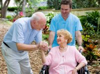 Caregiver with older couple out in nature